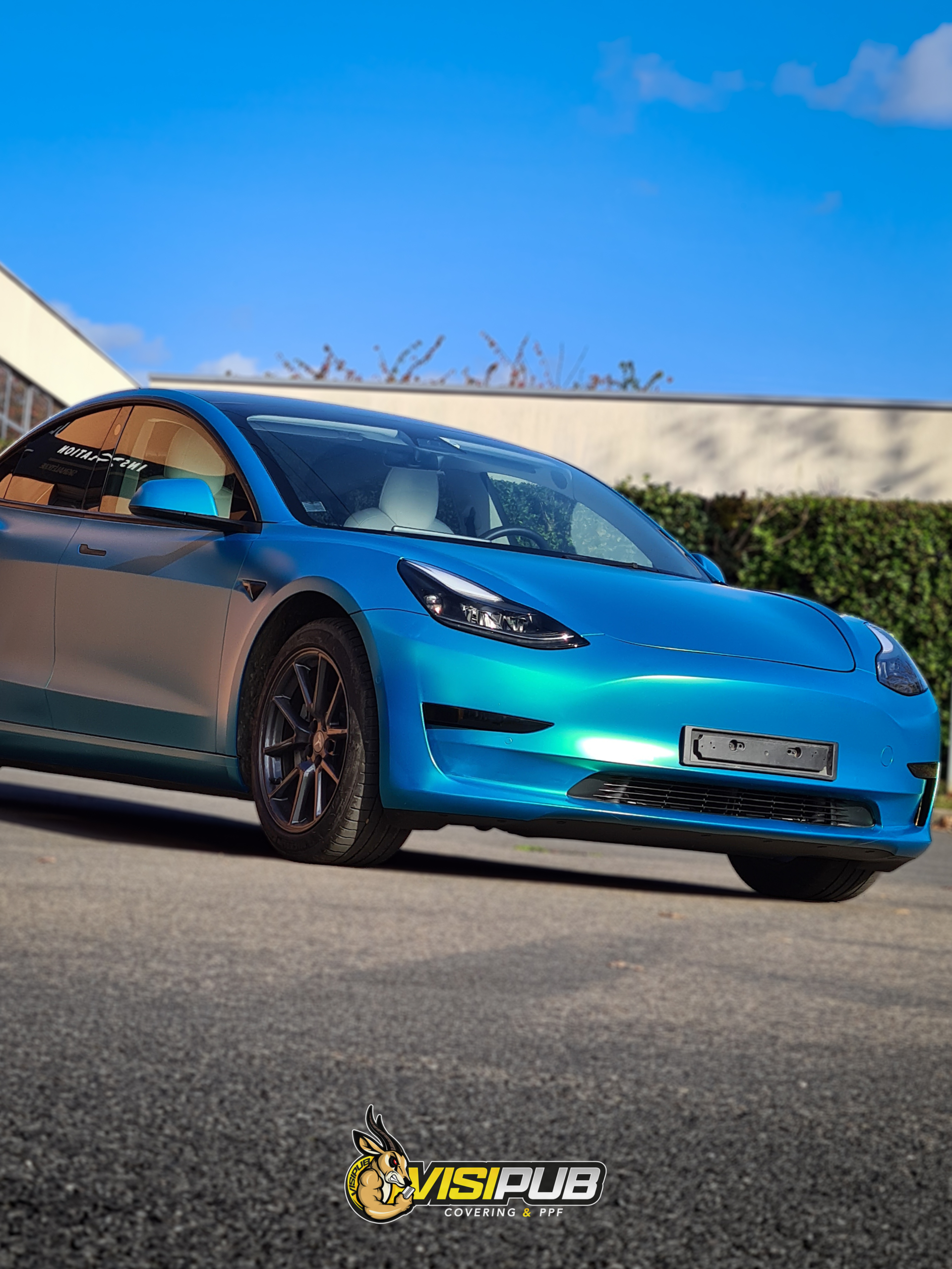 Changement d’apparence pour cette Tesla Model 3 d'origine blanche, avec une nouvelle couleur satiné et métallisé bleu aux reflet vert